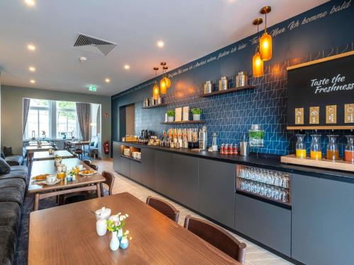 a restaurant with two tables and a bar at Mercure Hotel Luebeck City Center in Lübeck