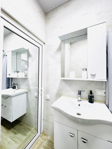 a white bathroom with a sink and a mirror at Heart of tbilisi 5 in Itʼkhvisi