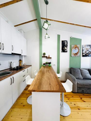 a kitchen and living room with a wooden table at Heart of tbilisi 5 in Itʼkhvisi