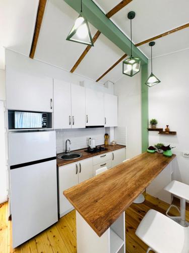 a kitchen with white cabinets and a wooden counter top at Heart of tbilisi 5 in Itʼkhvisi