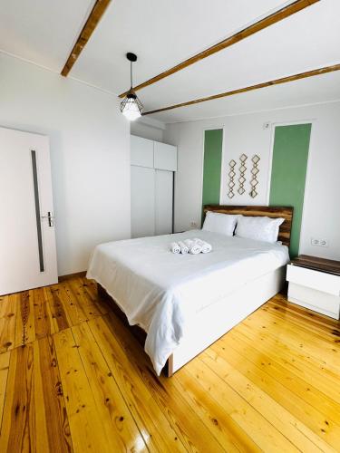 a bedroom with a large white bed and wooden floors at Heart of tbilisi 5 in Itʼkhvisi