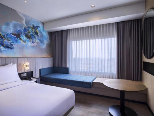 a hotel room with a bed and a window at Mercure Bengkulu in Bengkulu