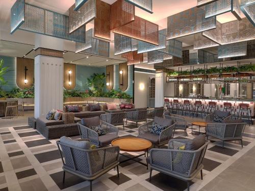 a lobby with chairs and tables and a bar at Mercure Bengkulu in Bengkulu