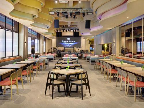 a restaurant with tables and chairs and a stage at Mercure Bengkulu in Bengkulu