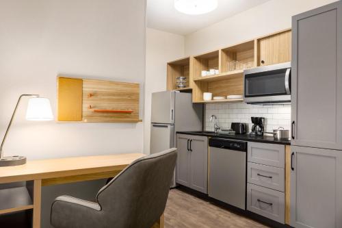 a small kitchen with a desk and a refrigerator at Candlewood Suites Anchorage - Midtown by IHG in Anchorage