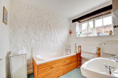 a bathroom with a tub and a sink at Tern Cottage in Wells next the Sea