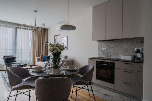 a kitchen and dining room with a table and chairs at Grzybowska Luxury Apartment with Skyline View by House Expert Warsaw in Warsaw
