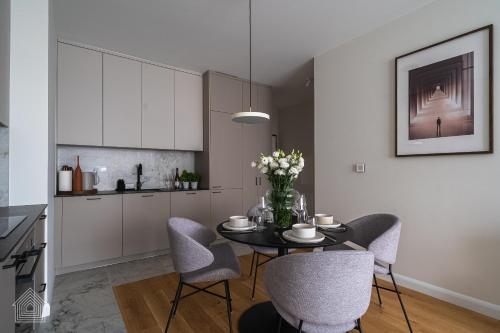 a dining room with a table and chairs in a kitchen at Grzybowska Luxury Apartment with Skyline View by House Expert Warsaw in Warsaw