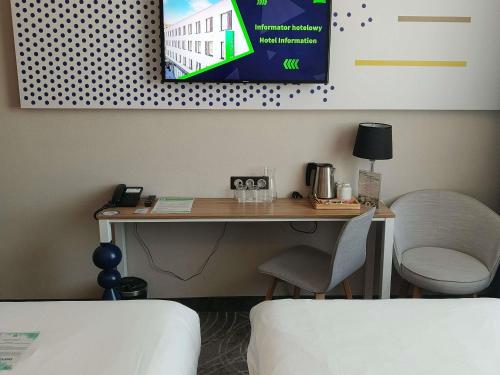 a desk in a room with a table and a chair at ibis styles Bolesławiec in Bolesławiec