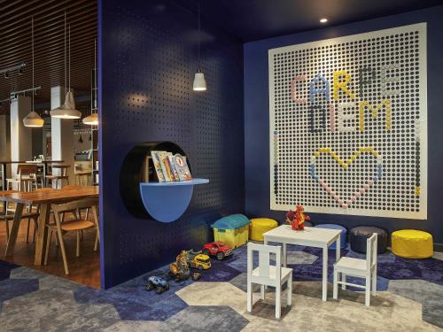 a room with a table and chairs and a wall with a picture at ibis styles Bolesławiec in Bolesławiec