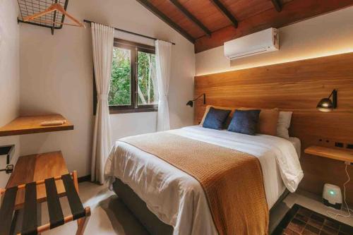 a bedroom with a large bed and a window at Odoyá Cabana à beria-mar in Governador Celso Ramos