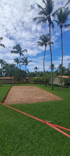 a dirt field with palm trees in a park at Porto do Sol - Chalé 25 in Pipa