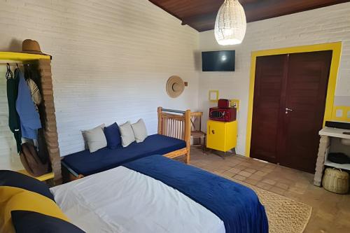 a bedroom with a bed with a blue blanket at Porto do Sol - Chalé 25 in Pipa