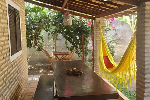 a patio with a hammock and a table and chairs at Porto do Sol - Chalé 25 in Pipa