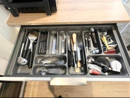 a drawer filled with utensils on a counter at Le Balandrau-Centre Argelès Gazost in Argelès-Gazost
