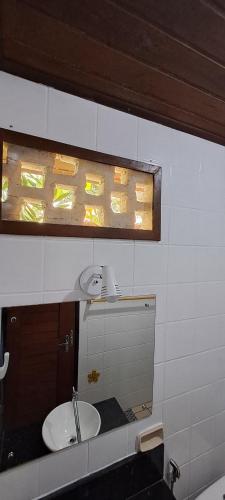 a bathroom with a sink and a mirror at Porto do Sol - Chalé 07 in Pipa