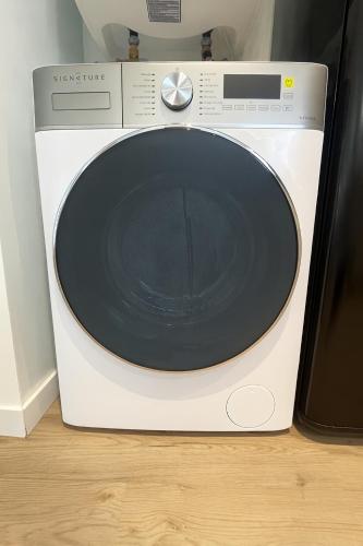 a white washing machine sitting on top of a floor at Le Balandrau-Centre Argelès Gazost in Argelès-Gazost
