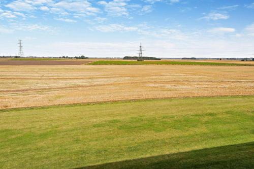 an empty field with green grass and two transmission towers at Aqueduct Barn in Upwell