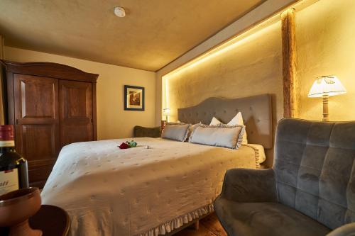 a bedroom with a large bed and a chair at Schinkel Ferienunterkünfte Quedlinburg UNESCO Altstadt, Parkplatz inkl in Quedlinburg