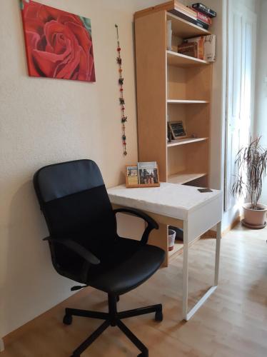 a black chair sitting at a white desk at Bern room near Main Station in Bern