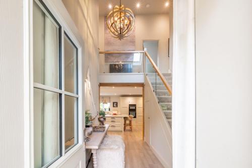 a hallway with a staircase with a chandelier at Little Butts in Blakeney