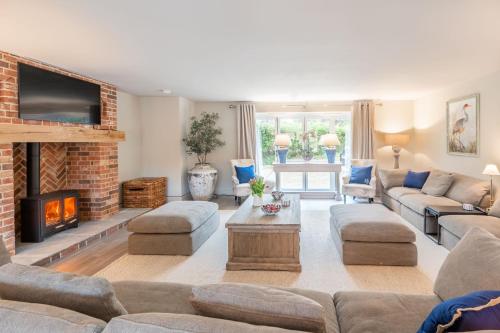 a living room with a couch and a fireplace at Little Butts in Blakeney