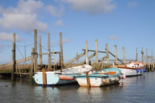 three boats docked at a dock in the water at Little Butts in Blakeney