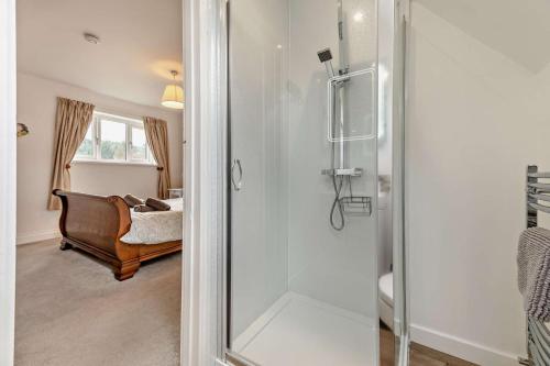 a shower with a glass door in a bathroom at Forest Retreat in Catcleugh