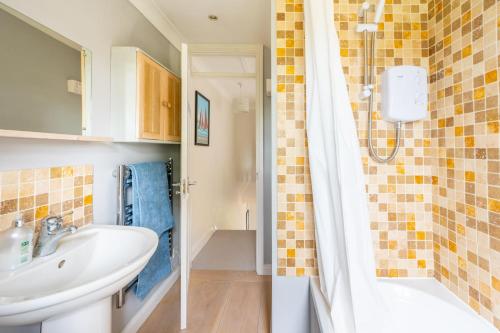 a bathroom with a sink and a shower at 2 Mallard Cottages in Tattersett