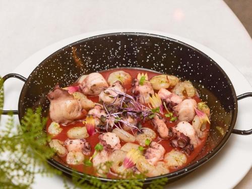 a pan filled with shrimp and vegetables in a sauce at Ibis Abdelmoumen Casa Centre in Casablanca