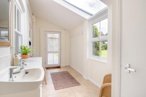 a bathroom with a sink and a window at Meadow Farmhouse in Whissonsett