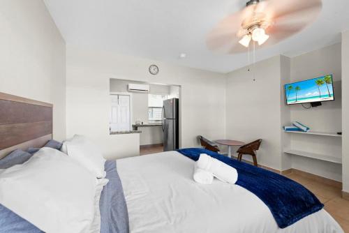 - une chambre avec un lit blanc et une couverture bleue dans l'établissement Cozy Studio in Lake With Pool & BBQ, à Lantana