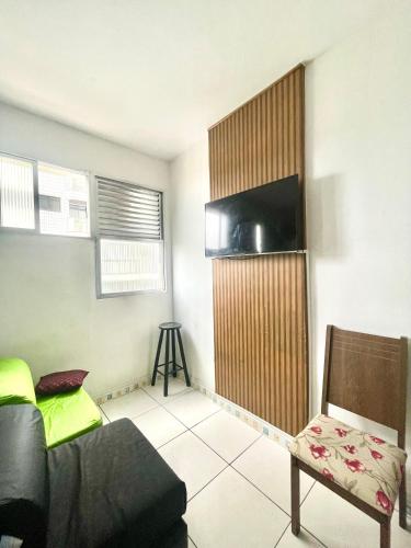 a living room with a couch a chair and a flat screen tv at Studio Infinity Beach in São Vicente