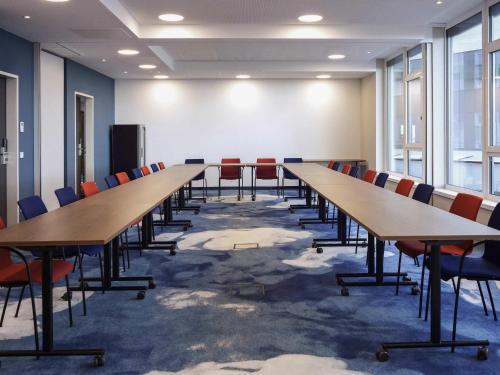a conference room with long tables and chairs at ibis Styles Parndorf Neusiedler See in Parndorf