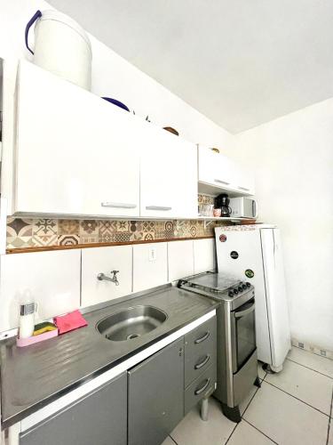 a small kitchen with a sink and a refrigerator at Studio Infinity Beach in São Vicente