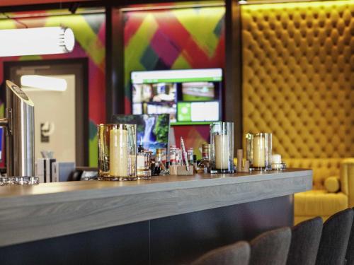 a counter in a restaurant with a bar with chairs at ibis Styles Parndorf Neusiedler See in Parndorf