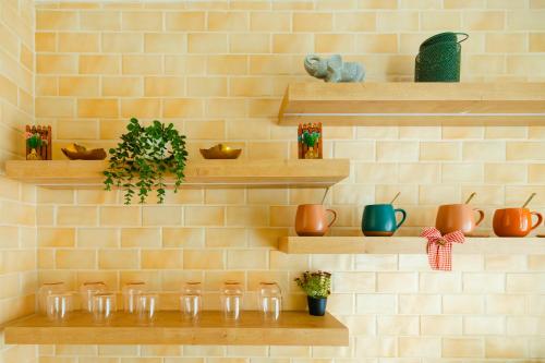 a wall with wooden shelves with pots and plants at Olive Stays Apartment - 2 in Pristina