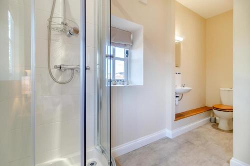 a bathroom with a shower and a toilet at The Coach House - Norfolk in Oxborough
