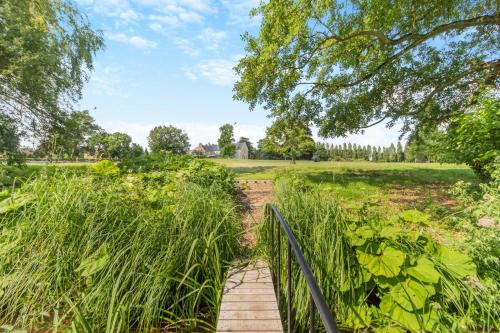 a wooden path through a field with a fence at The Coach House - Norfolk in Oxborough
