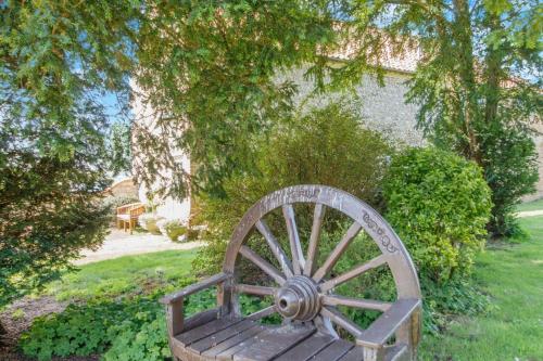 a wooden bench sitting in the grass in a yard at The Coach House - Norfolk in Oxborough