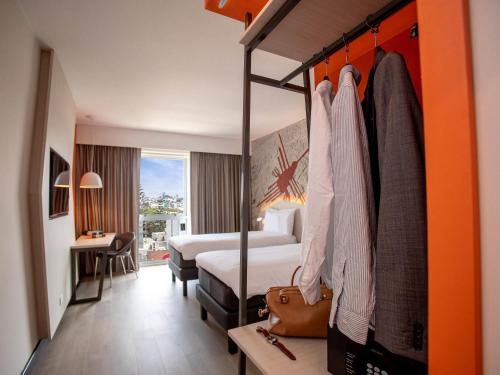 a hotel room with a bedroom with a bed and a room with a bed at ibis Styles Lima Benavides Miraflores in Lima