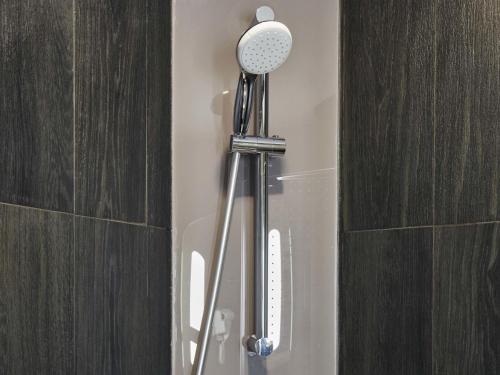 a shower head in a bathroom next to a wall at Ibis Aktobe in Aktobe