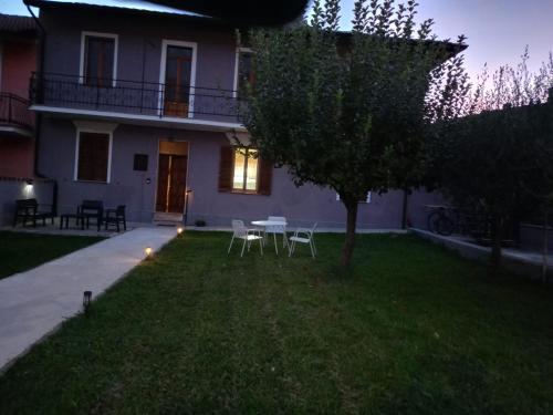 a house with a table and chairs in the yard at Alla Fonte in Massa dʼAlbe