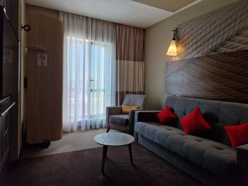a living room with a couch and a chair at Ibis Aktobe in Aktobe