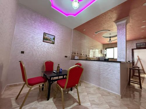 a dining room with red chairs and a table at Dream House Sidi Ifni in Sidi Ifni