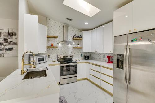 a kitchen with white cabinets and a stainless steel refrigerator at Fenced Yard, Game Room Family Home in Sebastian! in Sebastian