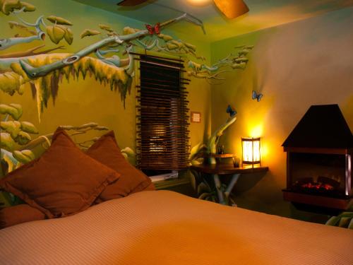 a bedroom with a bed with a tree mural on the wall at Gîte Crystal Inn in Mont-Tremblant