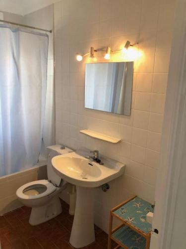 ein Badezimmer mit Toilette, Waschbecken und Spiegel in der Unterkunft Apartament 3 habitacions i espectaculars vistes al mar in Llança