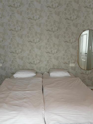 two twin beds in a bedroom with a mirror at cosy studio in Antwerp