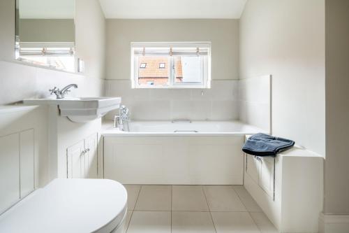 une salle de bain avec une baignoire, des toilettes et un lavabo dans l'établissement Creake Cottage, à Burnham Market